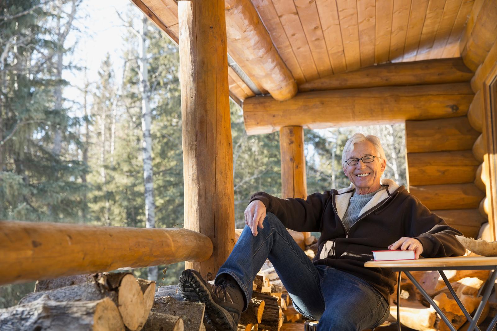 A retired client reading on the porch of his cabin in the pines