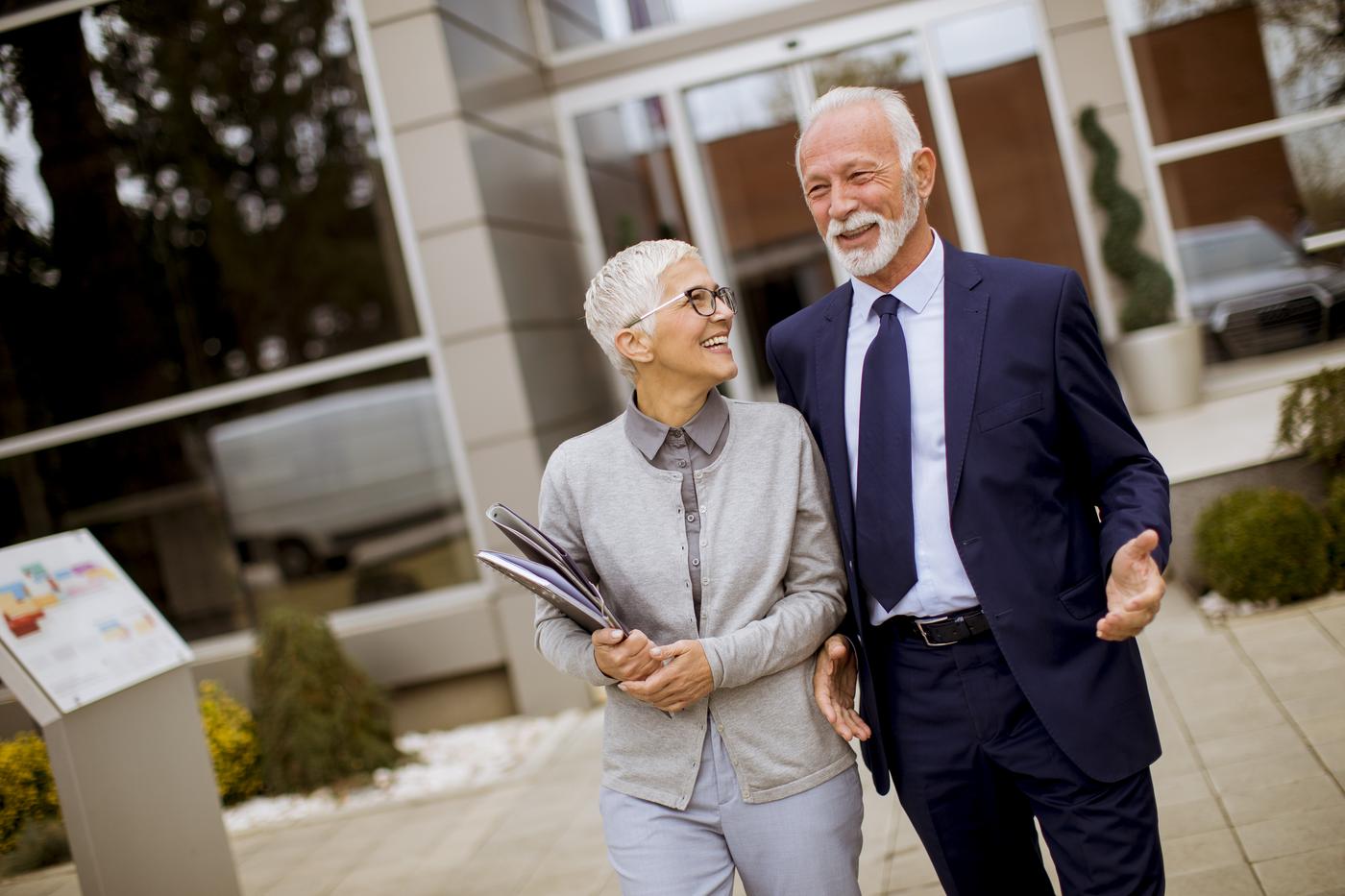 Two senior professionals talking as they walk between meetings