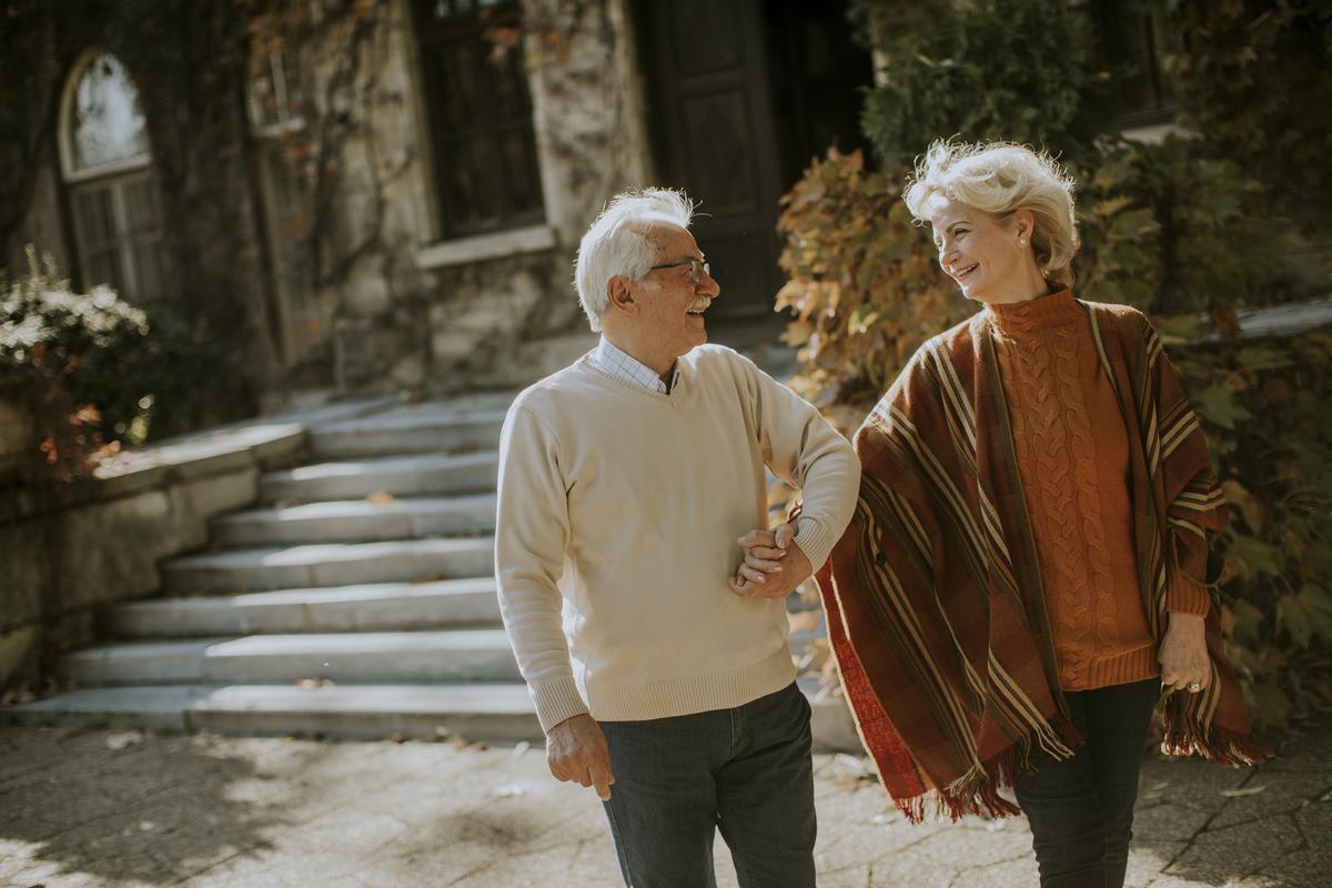 A couple walking arm in arm through an autumn morning