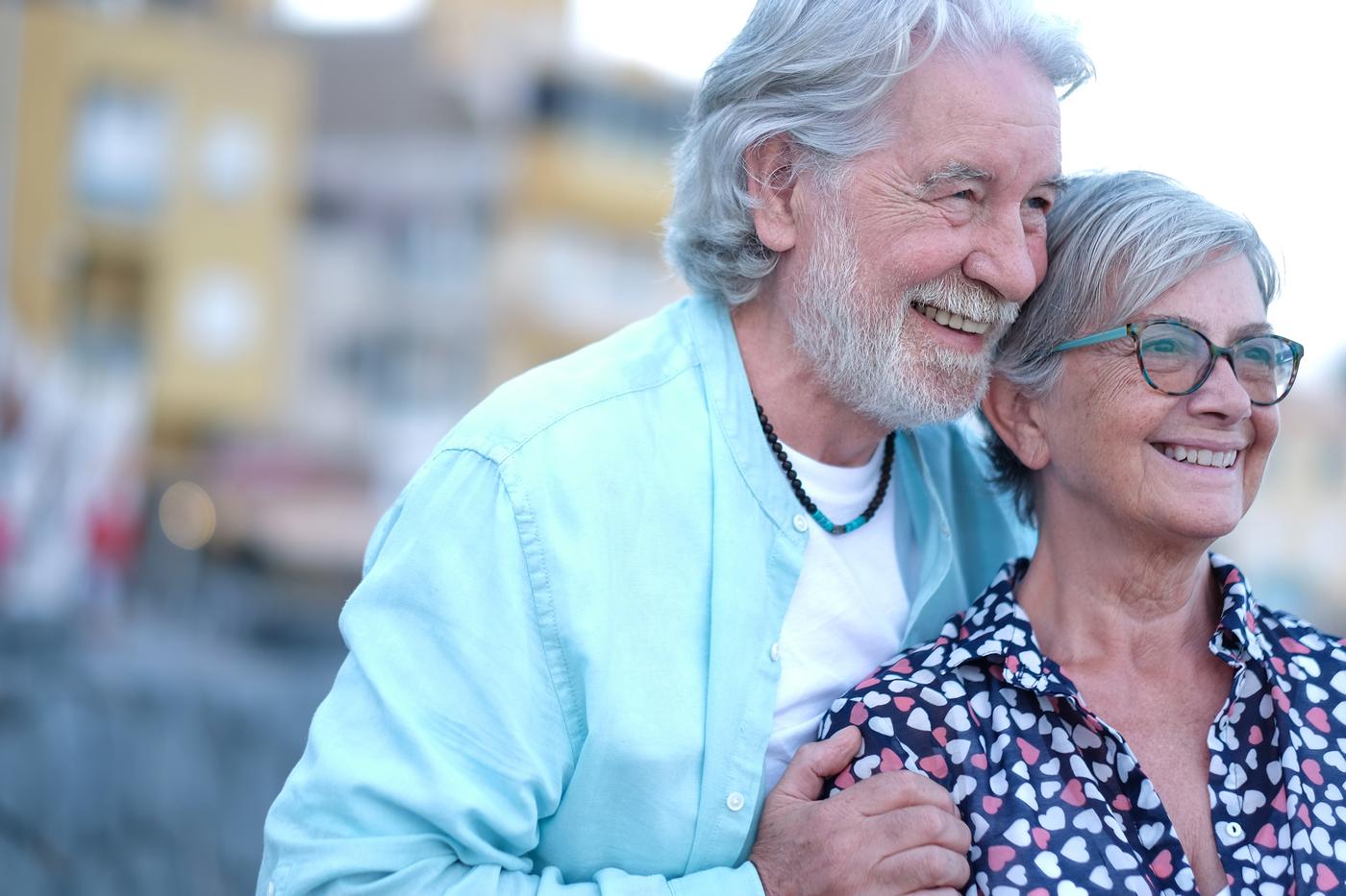 A retired couple laughing together in the sun on a trip they didn't have to think twice about