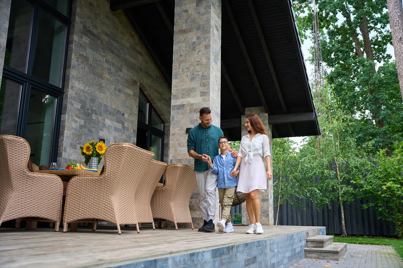 A young family walking along the terrace of the home they just built
